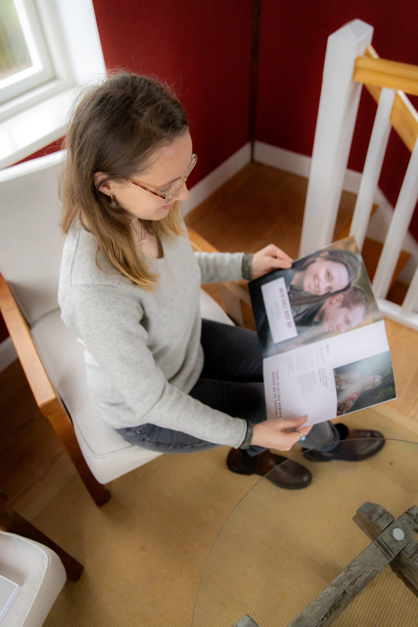 Liza Kummrow, Gründerin von Mitten ins Herz, hält ein Mitten ins Herz Magazin in den Händen und blättert durch die persönlichen Erinnerungen. Das emotionale Geschenk bewahrt Stimmen und Botschaften der Liebsten für die Ewigkeit. Perfekt für Hochzeiten, Jubiläen und besondere Momente. Du entscheidest ob als Einzelgeschenk oder in Kombination mit dem Podcast. Ein Geschenk für immer.
