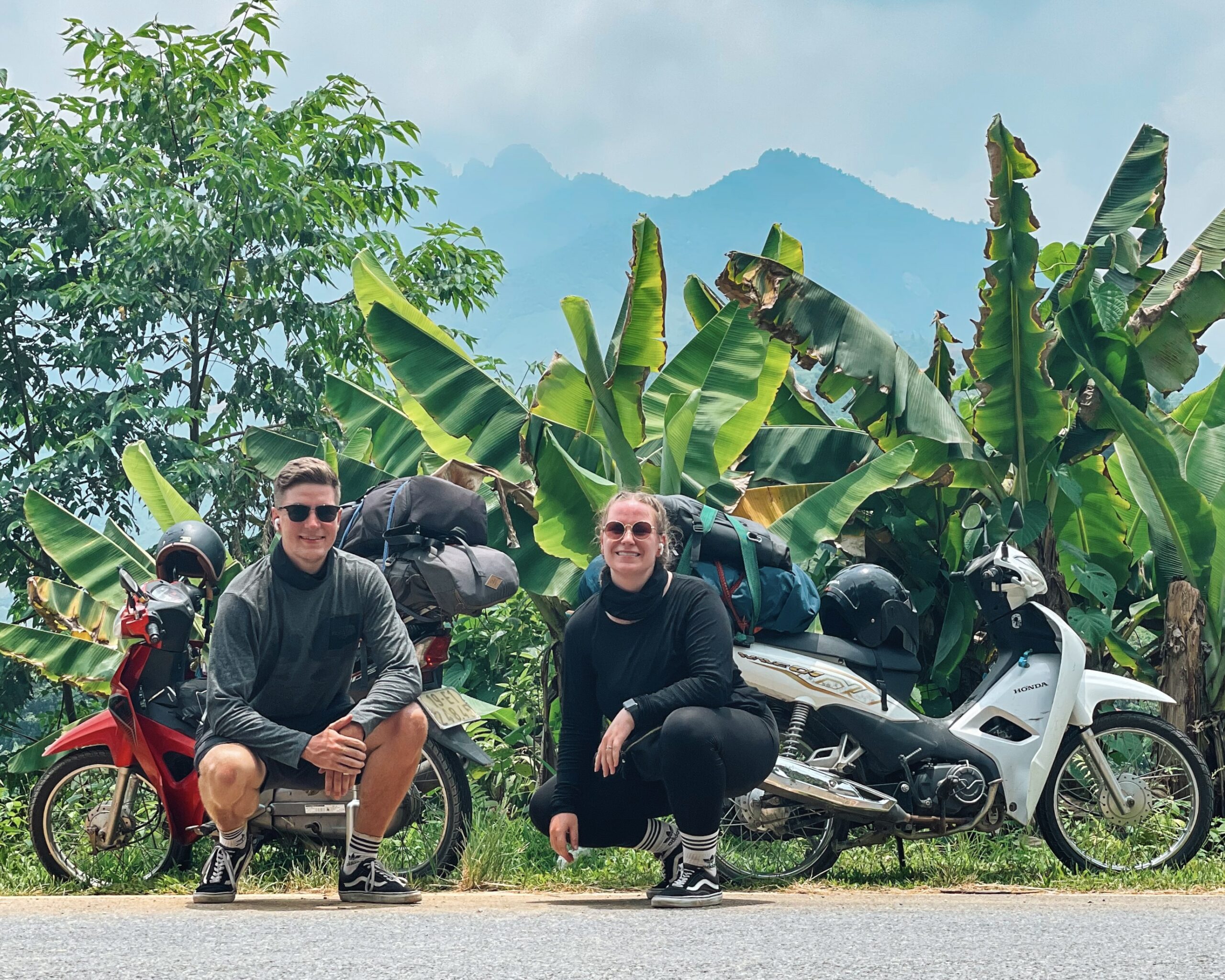Ein abenteuerlustiges Paar auf dem Ha Giang Loop in Vietnam, unterwegs mit vollgepackten Motorrädern. Ihre Reise führt sie durch atemberaubende Landschaften – doch die Stimmen ihrer Liebsten begleiten sie überall. Mit dem Mitten ins Herz Podcast haben sie Nachrichten von Familie und Freunden immer dabei. Das perfekte Geschenk für Reisende, die auch in der Ferne die Nähe ihrer Herzensmenschen spüren möchten.